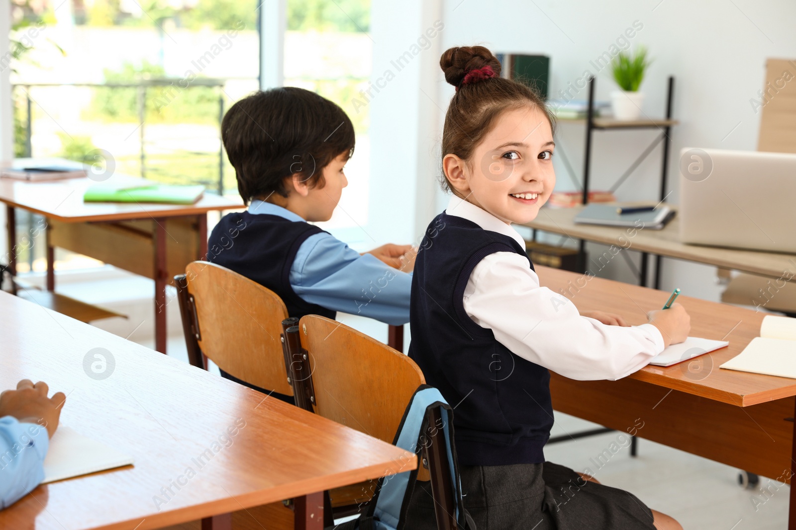 Photo of Girl wearing new school uniform in classroom