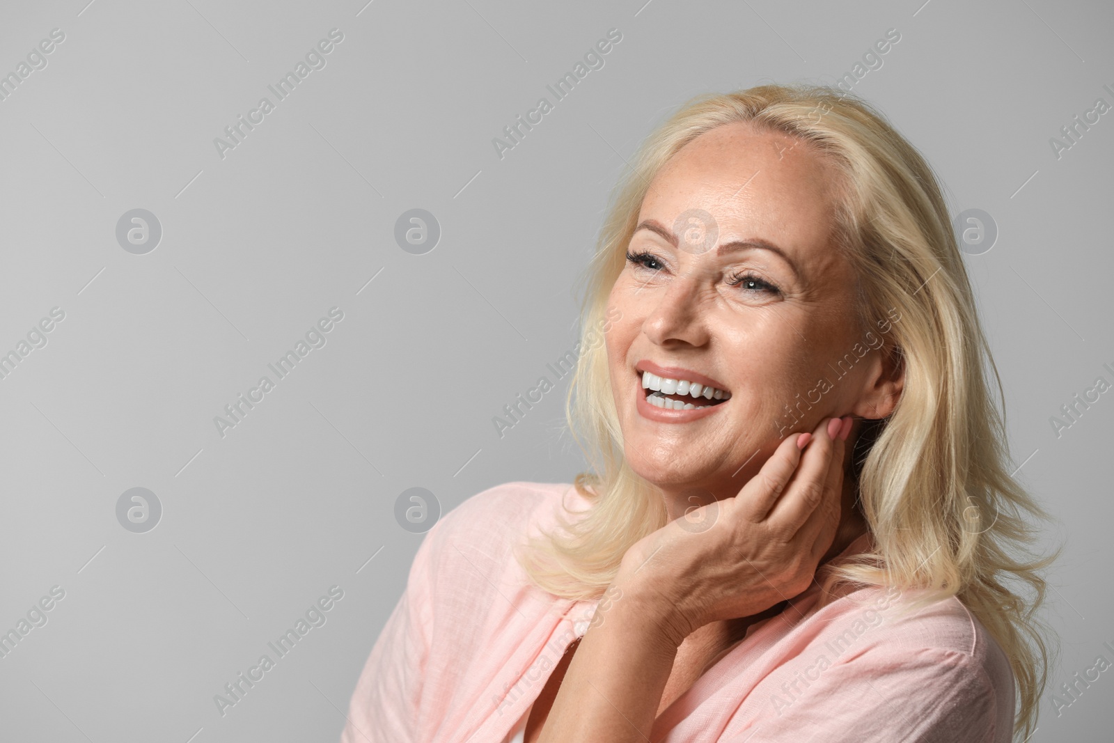 Photo of Portrait of beautiful mature woman with perfect skin on grey background. Space for text