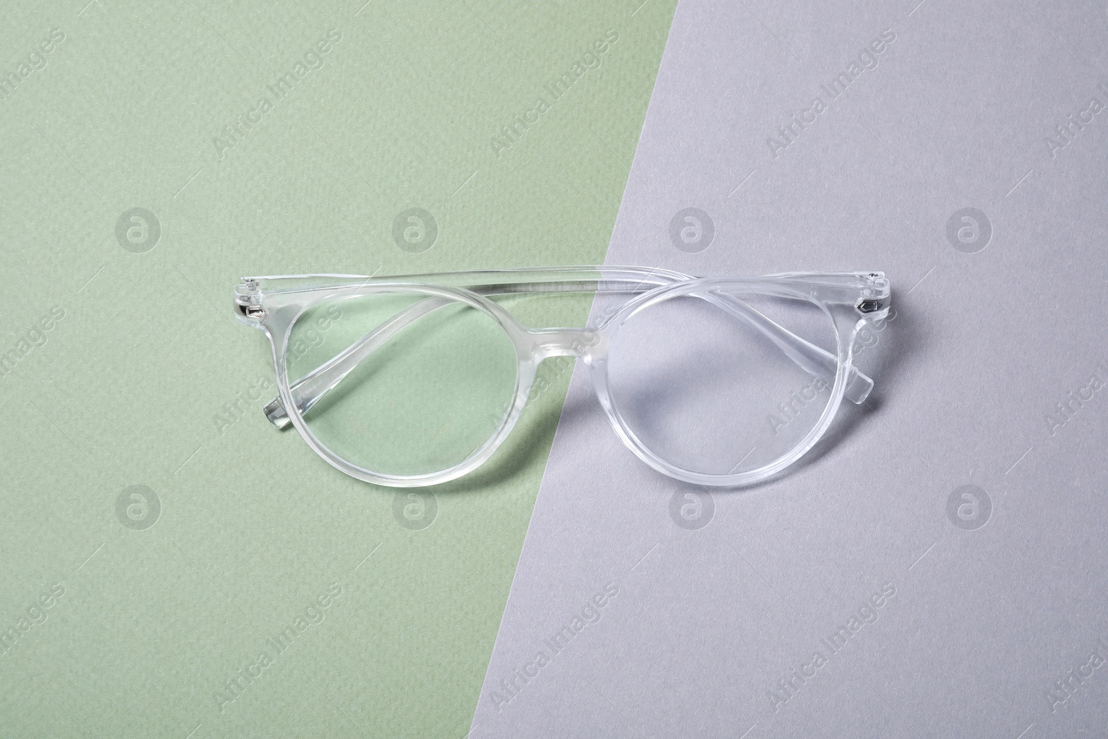 Photo of Stylish pair of glasses on color background, top view