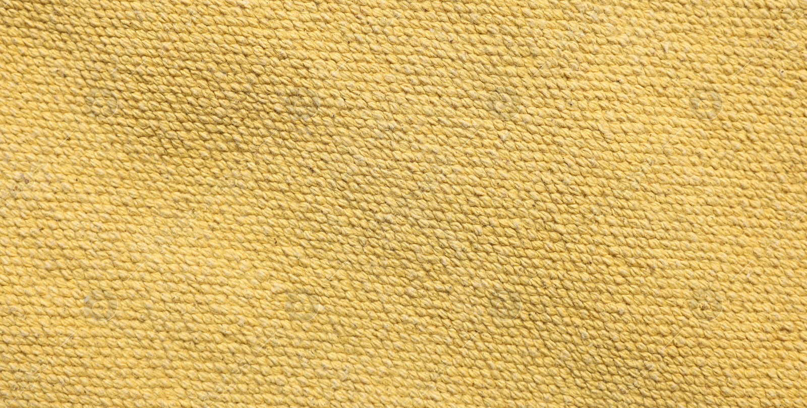 Photo of Texture of soft yellow fabric as background, top view