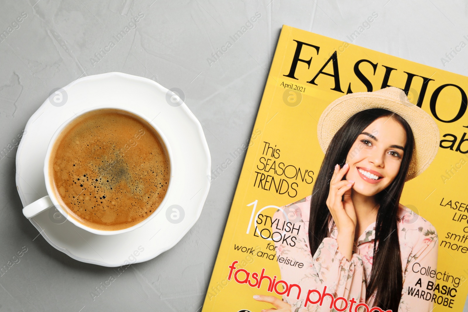 Photo of Fashion magazine and cup of coffee on grey table, flat lay