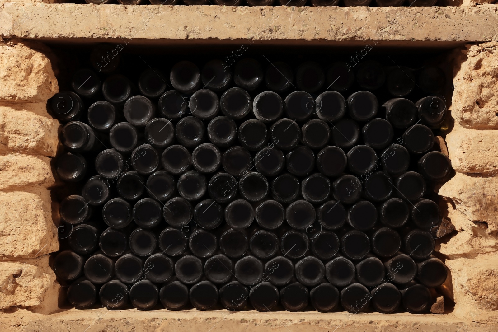 Photo of Many wine bottles on shelf in cellar