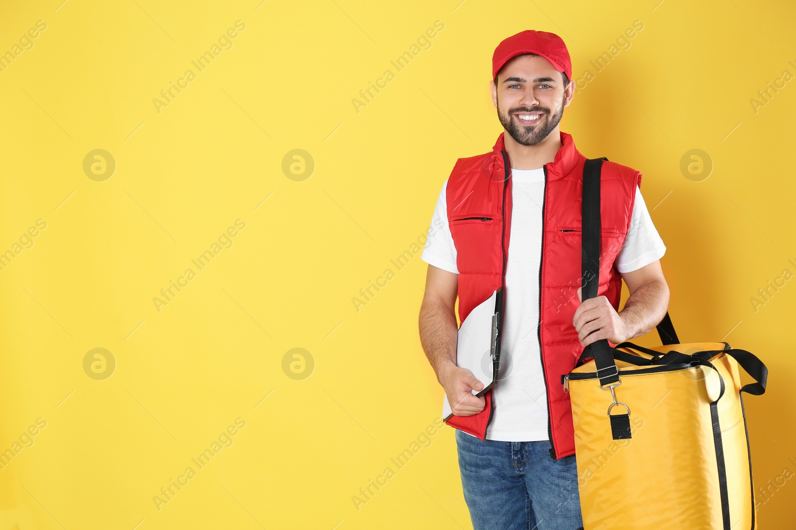 Photo of Courier with thermo bag on yellow background, space for text. Food delivery service