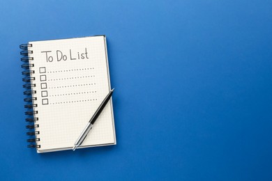 Photo of Notepad with unfilled To Do list and pen on blue background, top view. Space for text