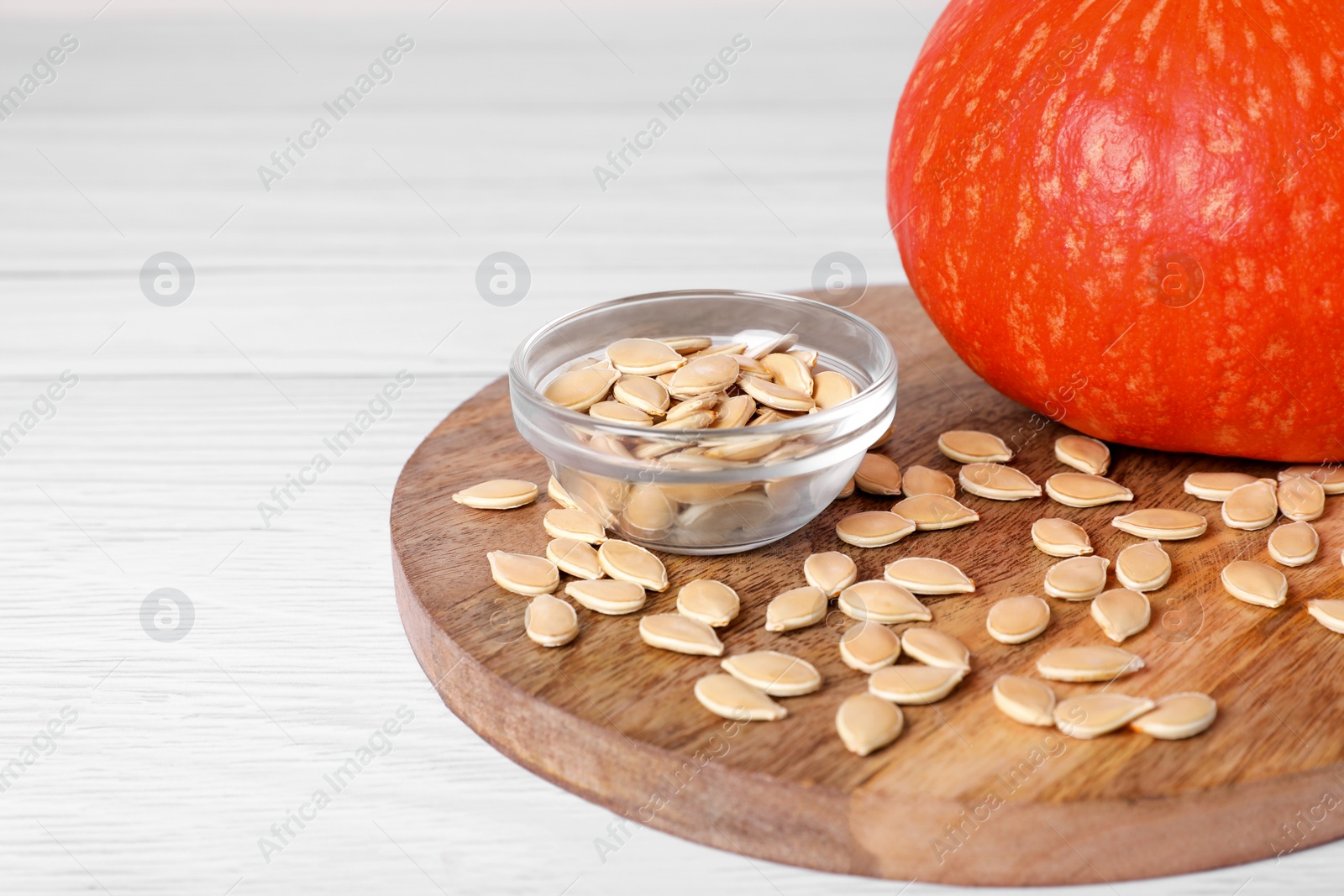 Photo of Fresh pumpkin and vegetable seeds on white wooden table, closeup. Space for text