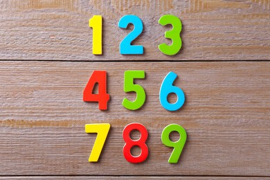 Colorful numbers on wooden table, flat lay