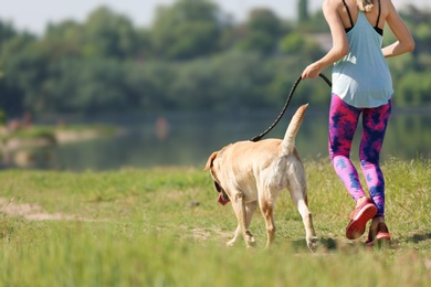 Young woman and her dog spending time together outdoors. Pet care