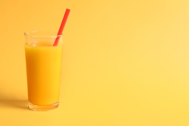 Photo of Glass of orange juice on color background