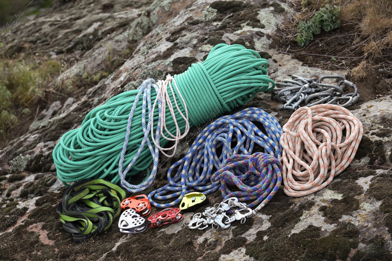 Photo of Different ropes and other climbing equipment on rock outdoors