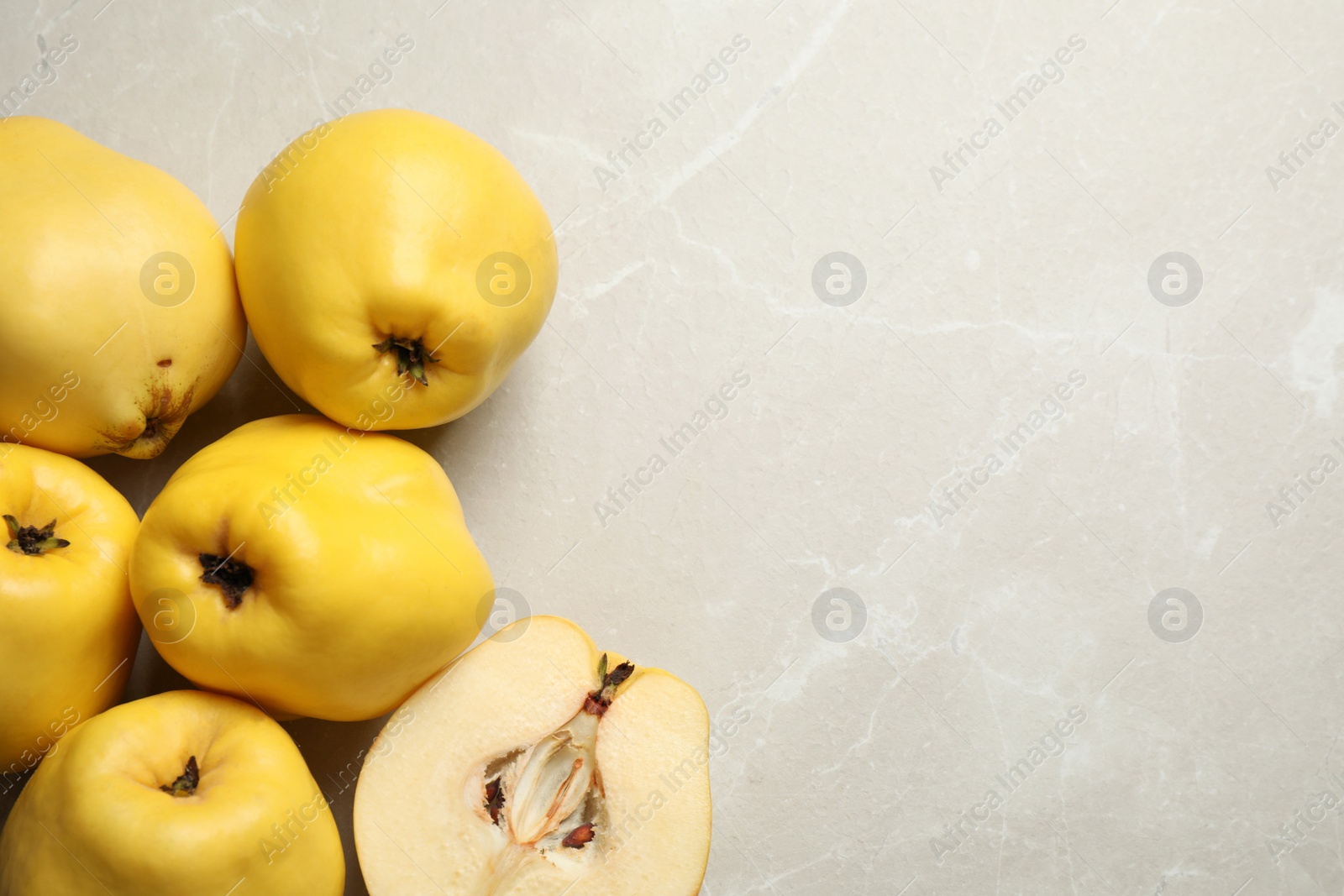 Photo of Fresh ripe organic quinces on light table, flat lay. Space for text