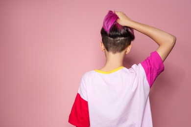 Photo of Young woman with trendy haircut against color background