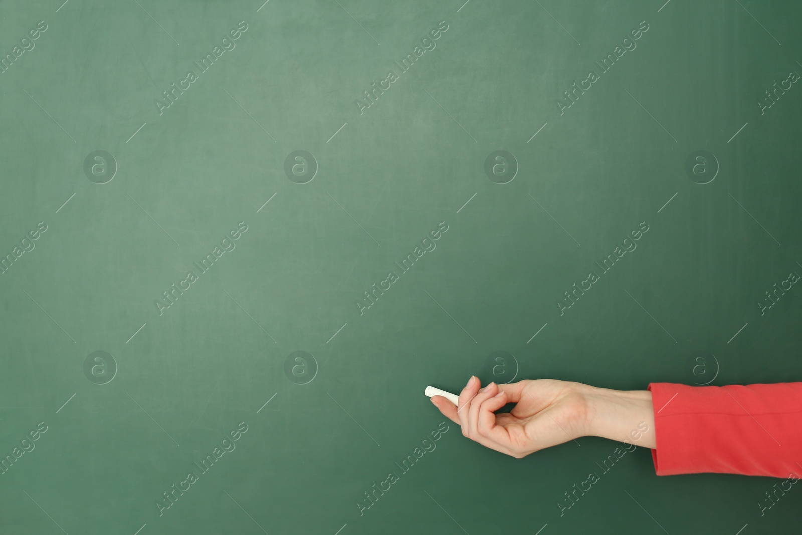Photo of English teacher near green chalkboard at lesson, closeup