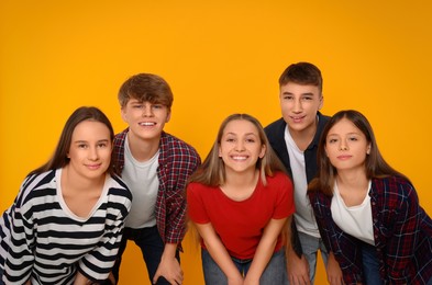 Photo of Group of happy teenagers on orange background
