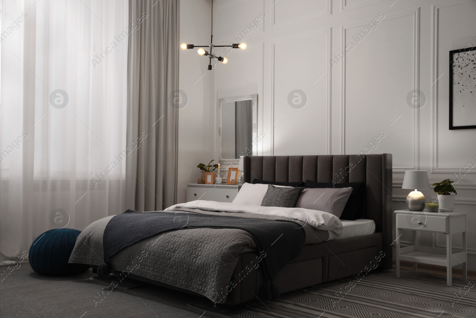 Photo of Stylish bedroom interior with large comfortable bed and table