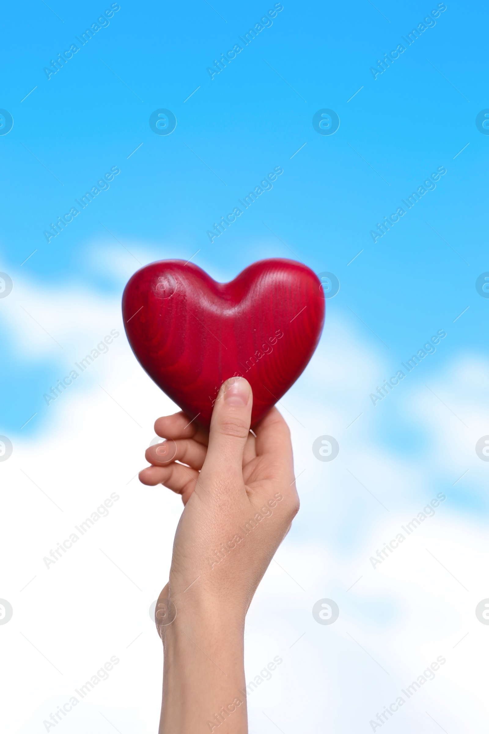 Photo of Woman holding decorative heart in hand on color background, closeup