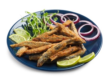 Photo of Plate with delicious fried anchovies, lime slices, microgreens and onion rings on white background