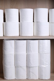 Photo of Stacked toilet paper rolls on wooden shelves