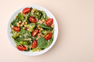 Photo of Healthy meal. Tasty salad with quinoa, chickpeas and vegetables on beige table, top view with space for text