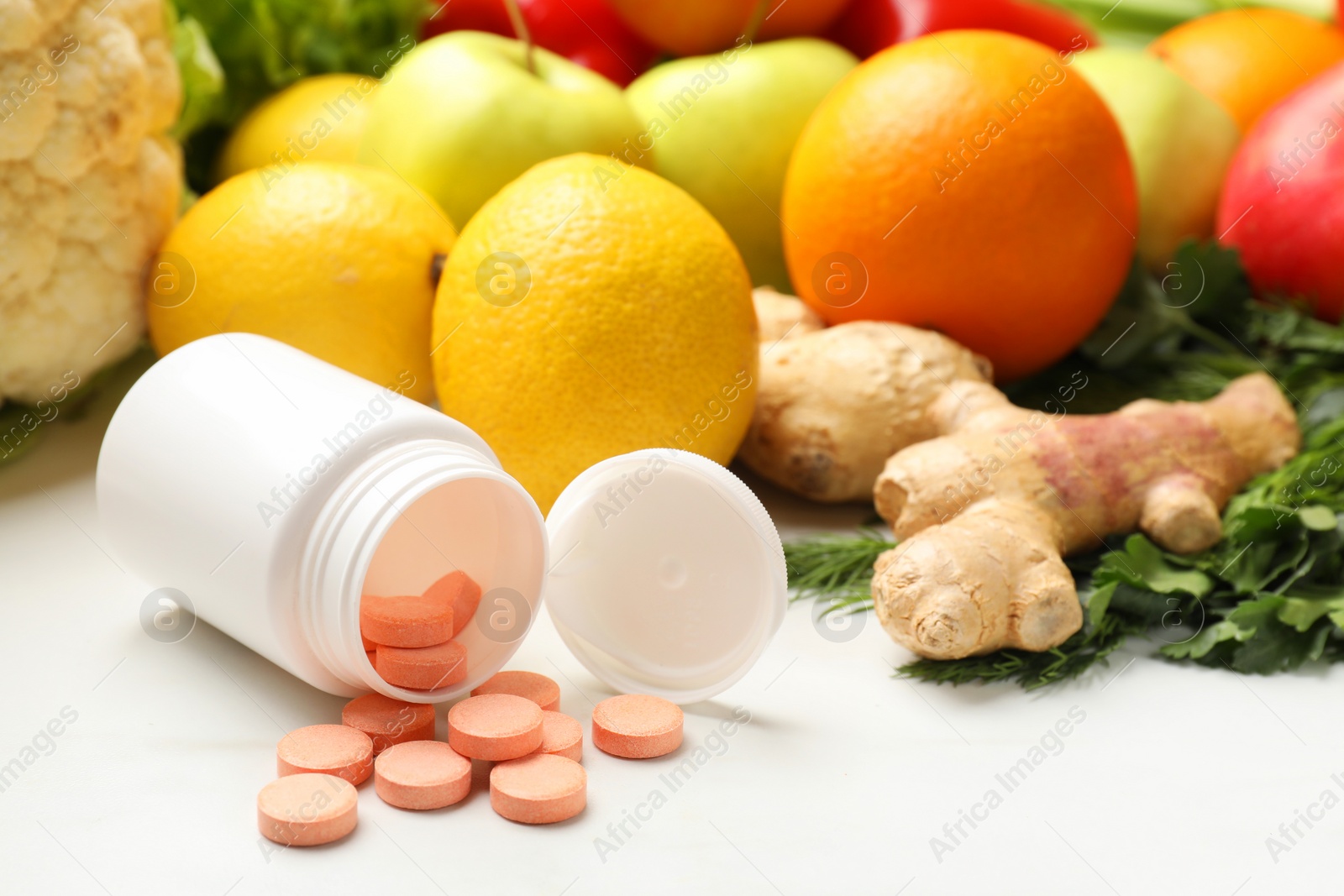 Photo of Dietary supplements in plastic bottle and products on white table, closeup