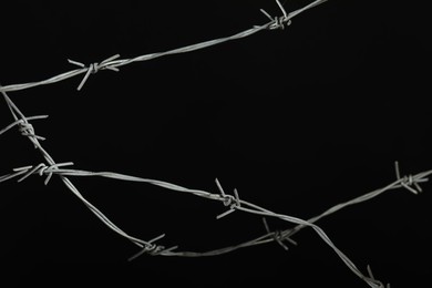 Shiny metal barbed wire on black background