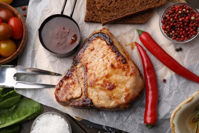 Photo of Tasty grilled meat, marinade, fork and chili on table, flat lay