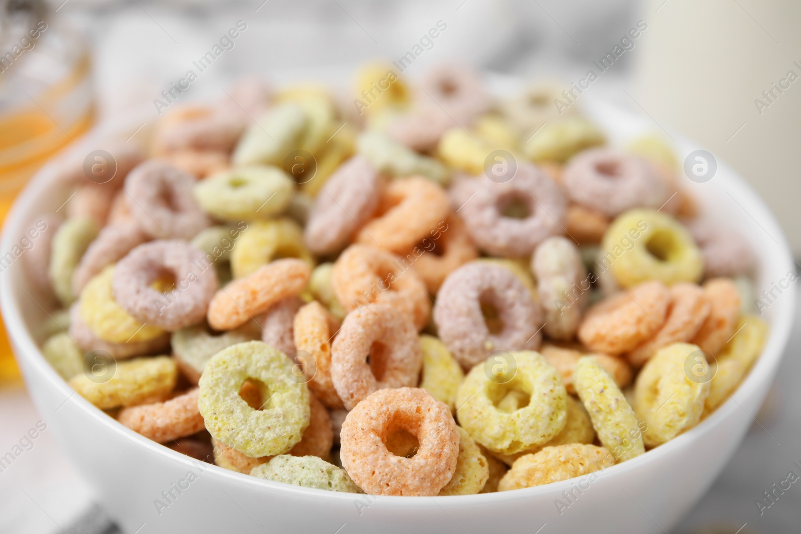 Photo of Tasty cereal rings in bowl on table, closeup