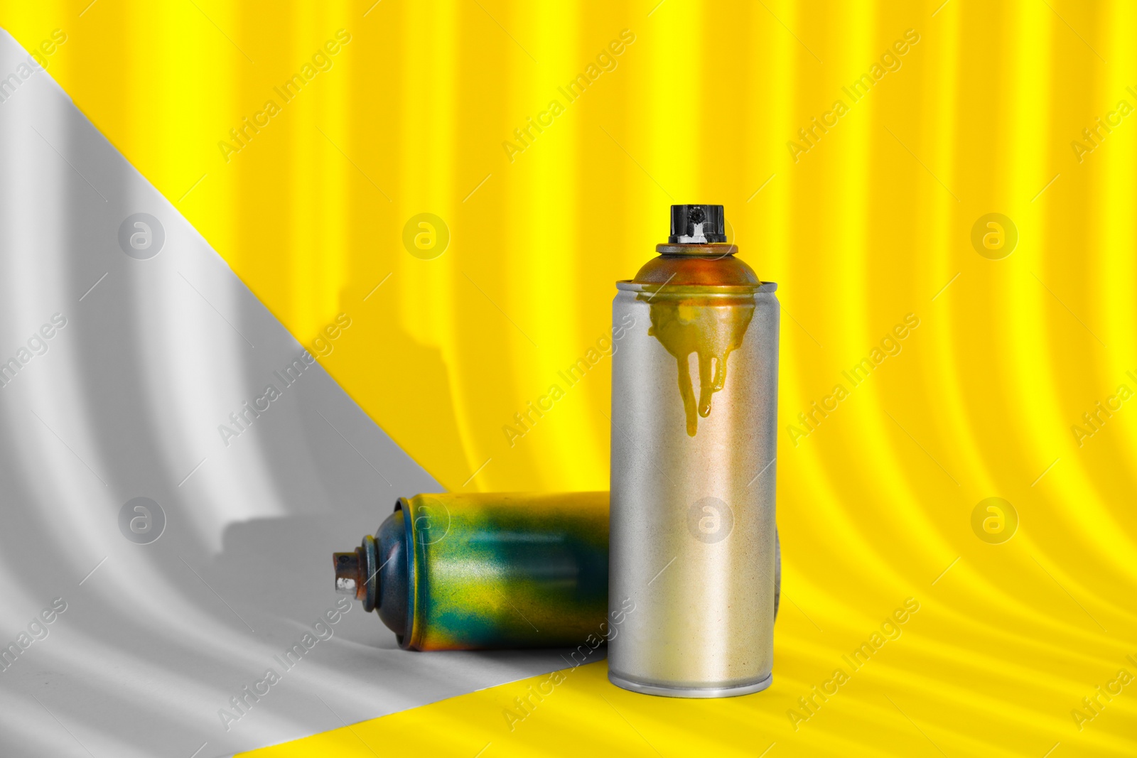 Photo of Used cans of spray paints on color background