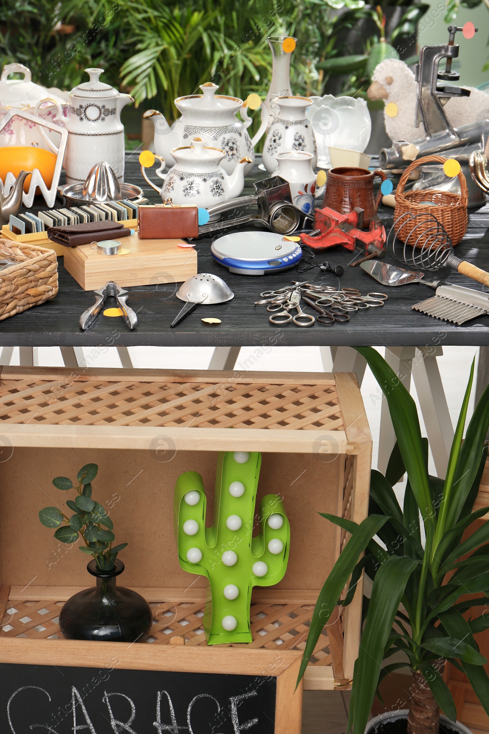 Photo of Many different stuff on black wooden table. Garage sale