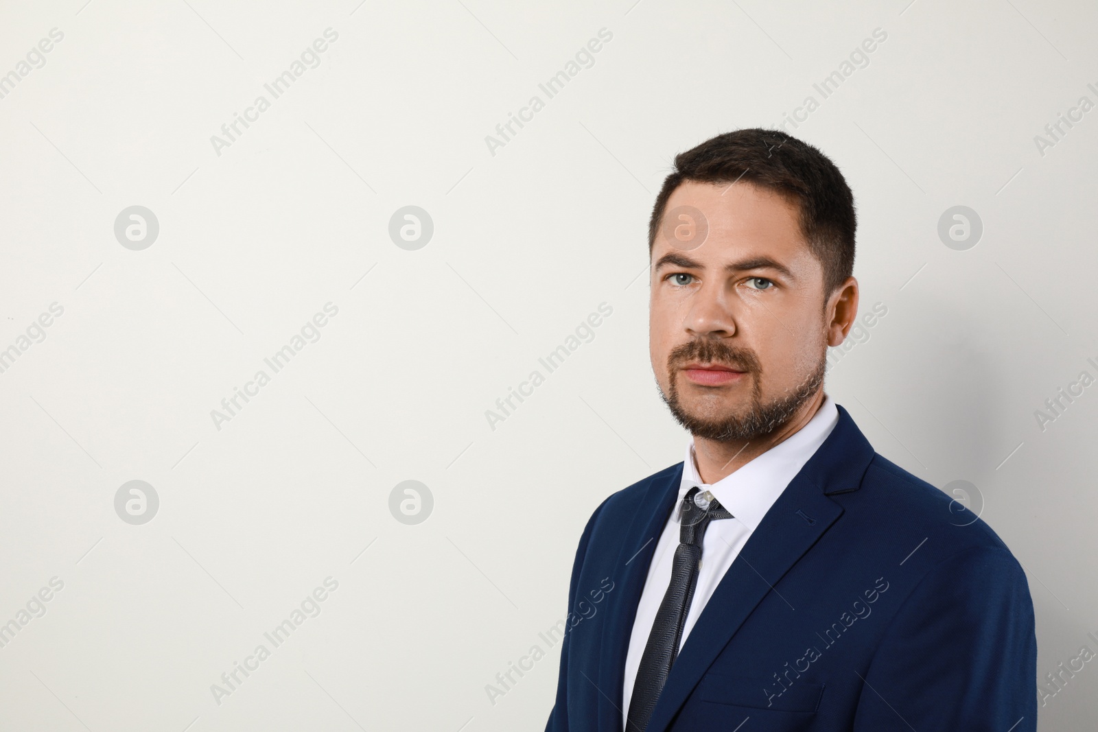 Photo of Portrait of handsome man in suit on light background. Space for text