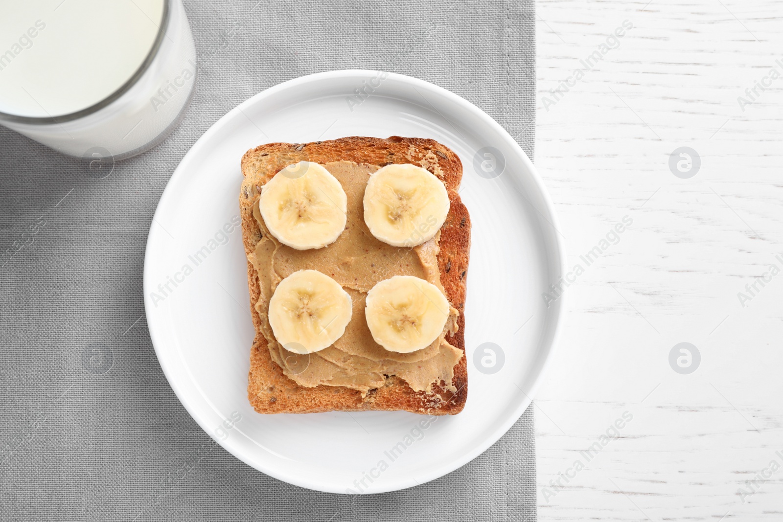 Photo of Toast with peanut butter and banana on white wooden table, flat lay. Healthy breakfast