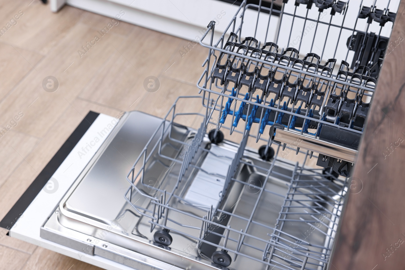 Photo of Open clean empty dishwasher in kitchen. Home appliance