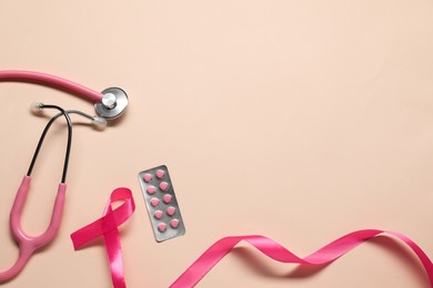 Photo of Breast cancer awareness. Pink ribbon, stethoscope and pills on beige background, flat lay. Space for text