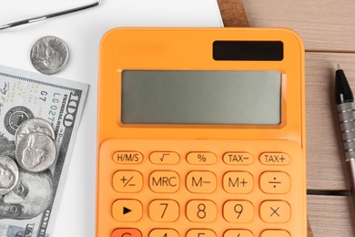 Orange calculator, money and clipboard with paper sheet on table, flat lay. Retirement concept