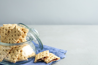 Tasty cookies with filling on light grey table. Space for text