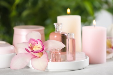 Photo of Beautiful spa composition with aroma oil and candles on marble table, closeup