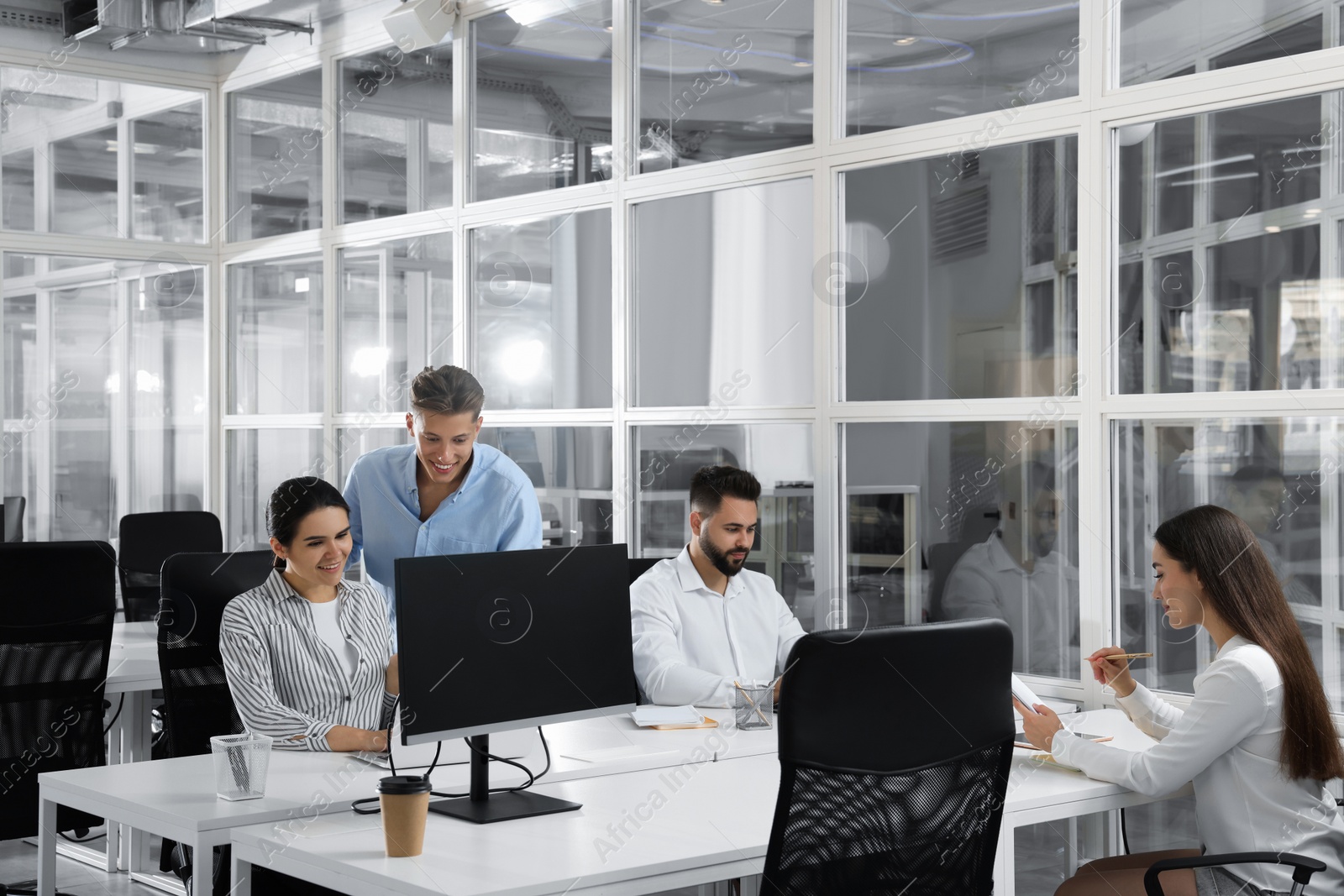 Photo of Colleagues working together in open plan office