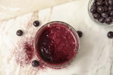 Photo of Glass with delicious acai smoothie on table, top view