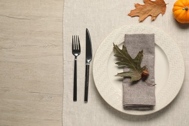 Photo of Autumn table setting, dry leaves and acorn, flat lay. Space for text