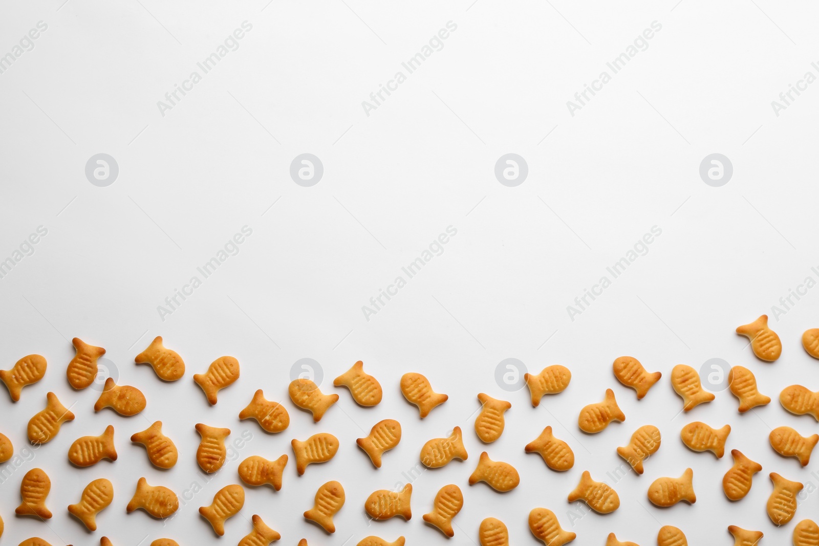 Photo of Delicious goldfish crackers on white background, top view