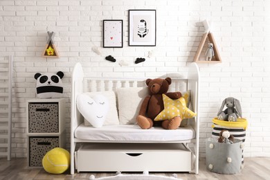 Photo of Cozy room with stylish furniture and toys for baby. Interior design