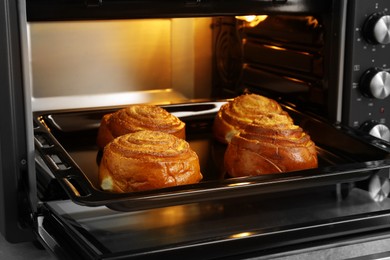 Photo of Open electric oven with delicious sweet pastry