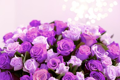 Bouquet of violet roses against blurred background, closeup. Funeral attributes