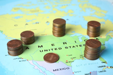 Photo of Different stacks of coins near USA on world map