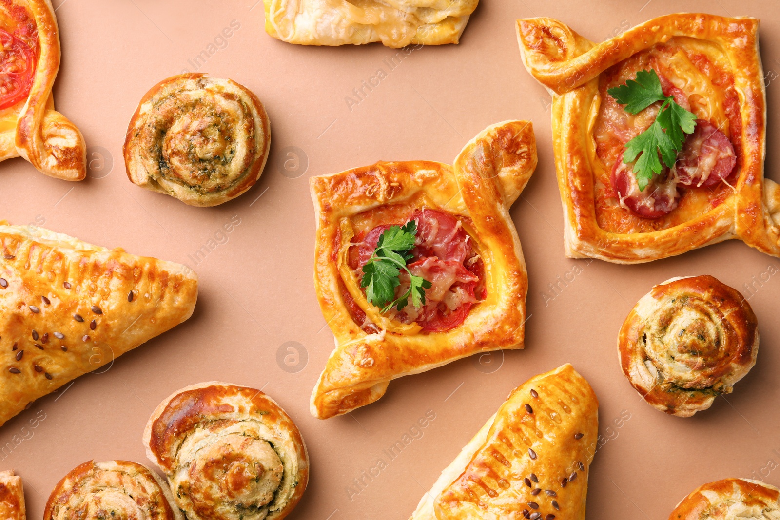 Photo of Different delicious puff pastry with tasty filling on beige background, flat lay