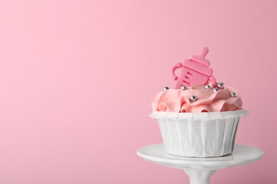 Baby shower cupcake with topper on pink background, closeup. Space for text