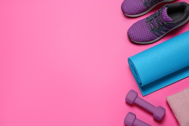 Photo of Exercise mat, dumbbells, towel and shoes on pink background, flat lay. Space for text
