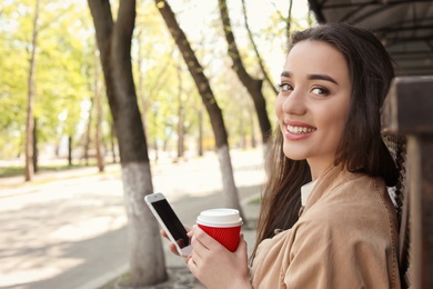 Photo of Young woman using phone outdoors on sunny day