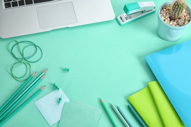 Photo of Workplace with stationery in mint color shades and laptop
