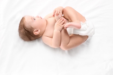 Photo of Cute little baby lying on white background, top view