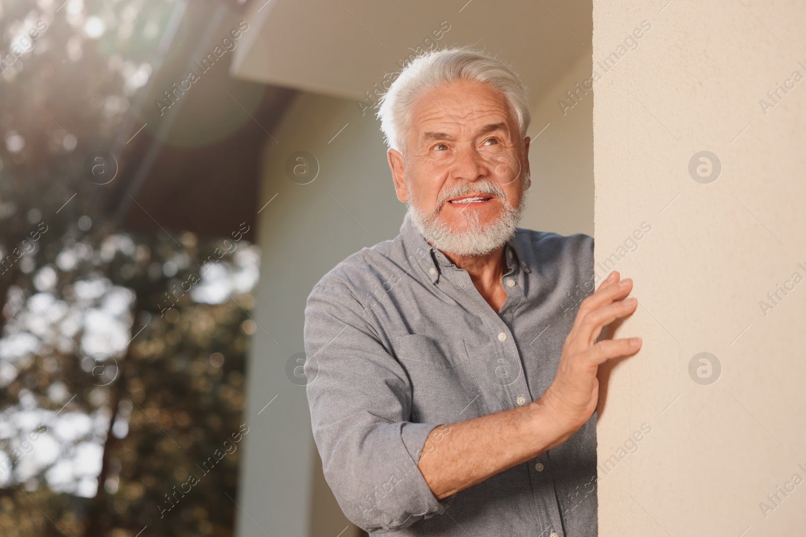 Photo of Portrait of senior man near house outdoors, space for text. Annoying neighbour